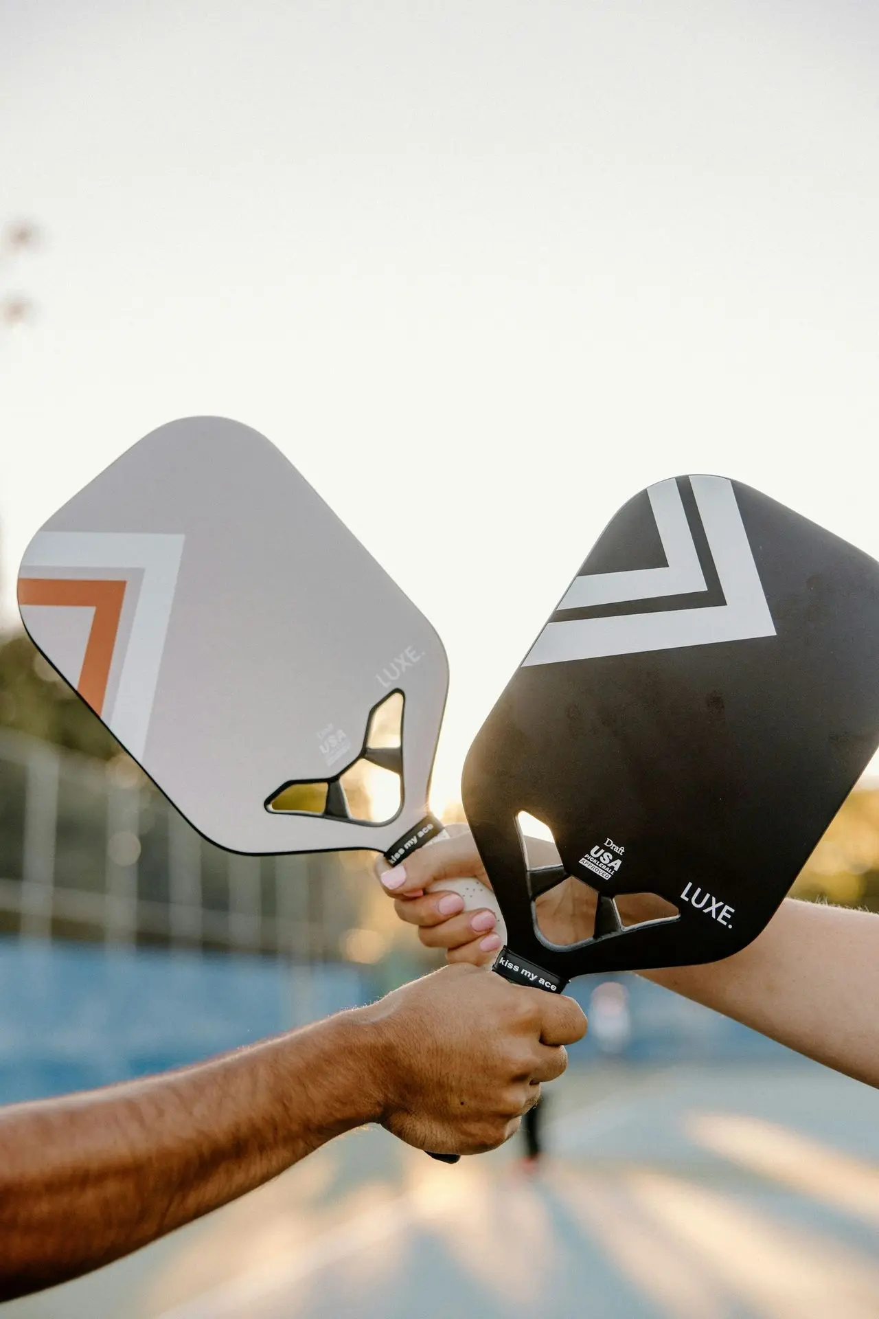 Dos personas sosteniendo palas de pickleball
